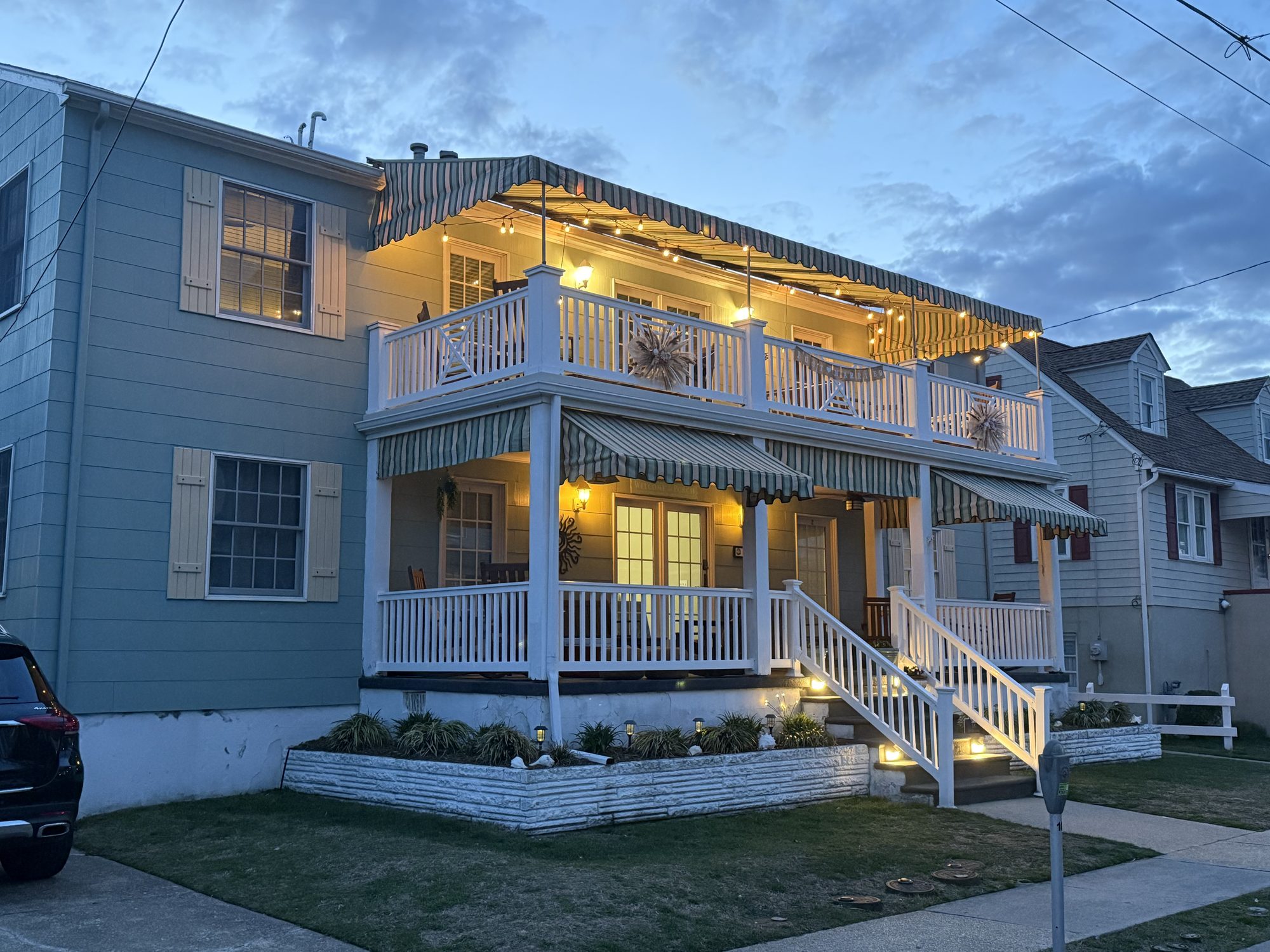 Suites on Jefferson at twilight, with warm porch lights and striped awnings