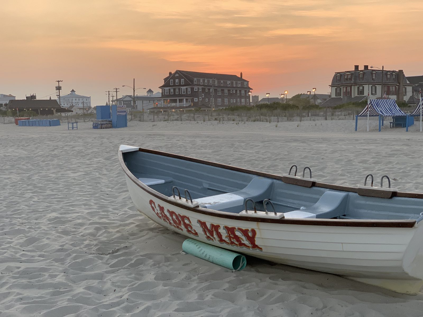 A Cape May lifeguard boat resting on the sand at sunset